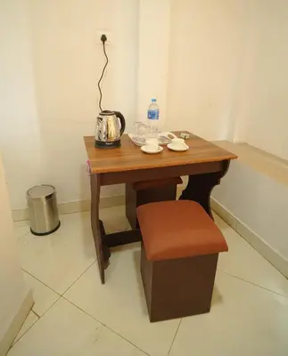 a small wooden table with a chair and a bottle of water at Port View Residency PVR in Nedumbassery