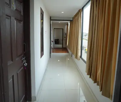 an empty hallway with a door and a hallway with windows at Port View Residency PVR in Nedumbassery