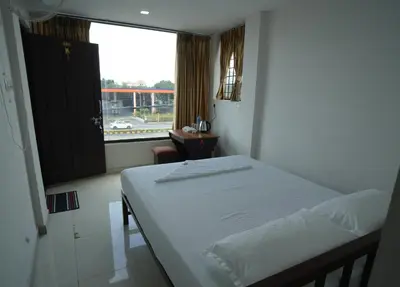 a small bedroom with a bed and a window at Port View Residency PVR in Nedumbassery