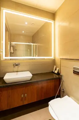 a bathroom with a sink and a mirror at 0484 Aero Lounge-Terminal 2 Cochin Airport Hotel in Nedumbassery