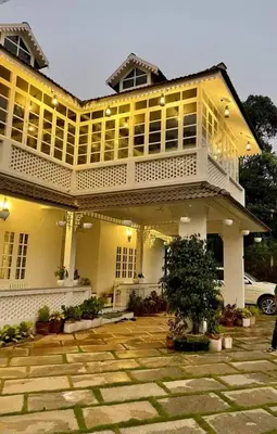 a large white building with a lot of windows at Padikkal Bungalow in Vayittiri