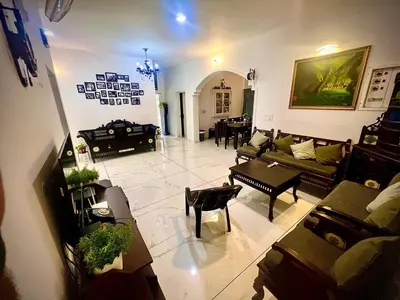 a large living room with couches and tables at Padikkal Bungalow in Vayittiri