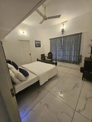 a bedroom with a bed and a ceiling fan at Padikkal Bungalow in Vayittiri