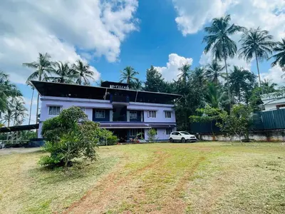 a white house with a car parked in front of it at D Villas in Kunnamangalam