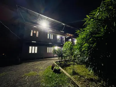 a building with a light on the side of it at night at D Villas in Kunnamangalam