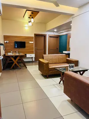 a living room with a couch and a table at Focuz Habitat Hotel And Ayurveda in Malappuram