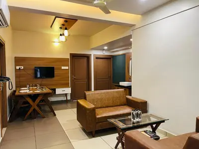 a living room with a couch and a table at Focuz Habitat Hotel And Ayurveda in Malappuram