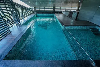 a large pool of blue water in a building at Focuz Habitat Hotel And Ayurveda in Malappuram