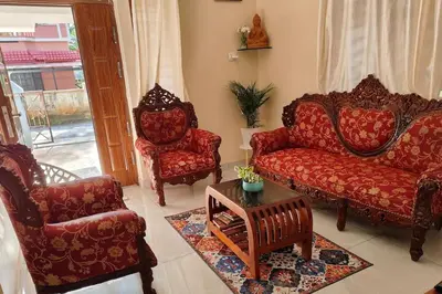 a living room with couches and chairs and a table at Krishnarpanam 2BHK villa in Guruvayoor- only for families in Guruvāyūr