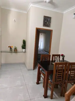 a dining room with a black table and chairs at Krishnarpanam 2BHK villa in Guruvayoor- only for families in Guruvāyūr