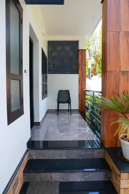 a hallway of a house with a chair on a balcony at Ecostay inn in Sultan Bathery