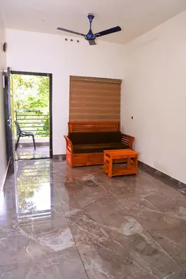 a living room with a couch and a table at Ecostay inn in Sultan Bathery