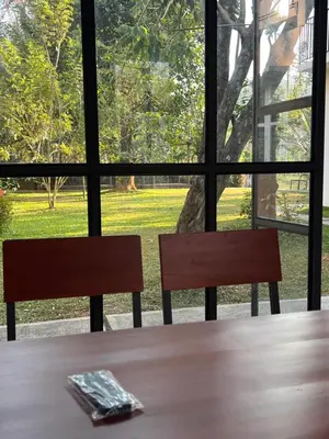 a table and two chairs in front of a window at Hill View Heights Wayanad in Meppādi