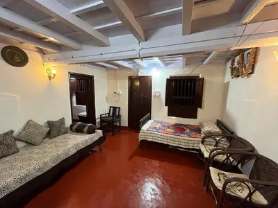 a room with two beds and chairs in it at TauSco Homestay & Campsite - Coorg in Madikeri