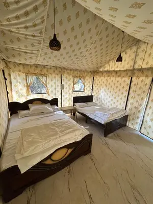 a bedroom with a bed and a table in a room at TauSco Homestay & Campsite - Coorg in Madikeri