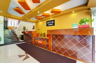 a lobby of a hotel with a lifto sign on the wall at Super Hotel O Thrissur Near Thrissur Medical College in Trichūr