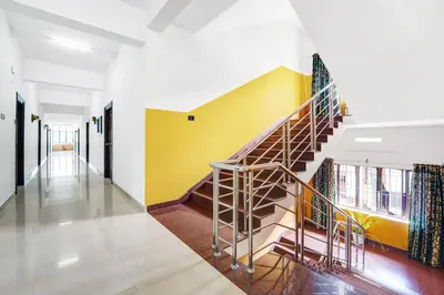 a staircase in a building with a yellow wall at Super Hotel O Thrissur Near Thrissur Medical College in Trichūr