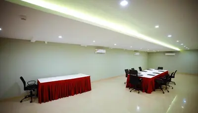 a conference room with two tables and black chairs at hotel emperor in Sultan Bathery