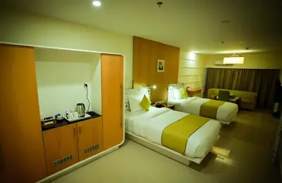 a hotel room with two beds and a desk at hotel emperor in Sultan Bathery