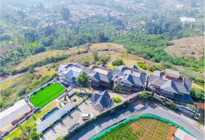 an aerial view of a house with a tennis court at Kanavu Valley View in Ooty