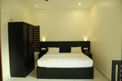 a bedroom with a large bed with a black headboard at Mountain Wings Resort in Vythiri