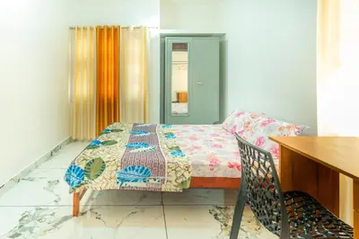 a room with a bed and a table and a chair at Be My Guest in Kozhikode