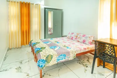 a bedroom with a bed and a table at Be My Guest in Kozhikode