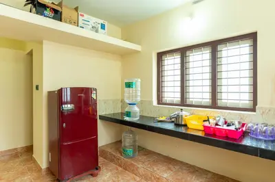 a kitchen with a red refrigerator and a counter at Be My Guest in Kozhikode