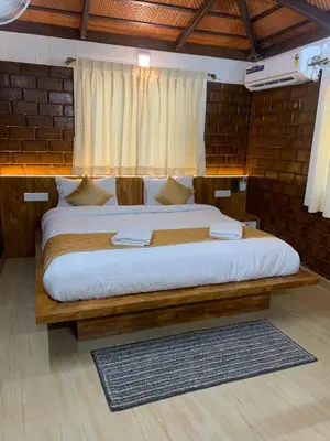 a bedroom with a large bed with white sheets at Love Green Resorts in Palladam