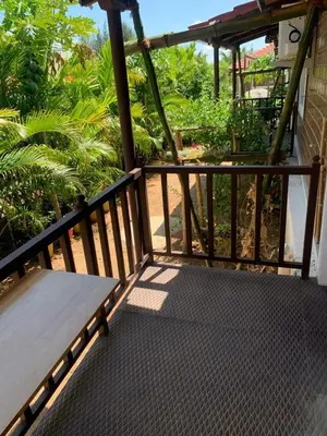 a wooden porch with a bench on a balcony at Love Green Resorts in Palladam