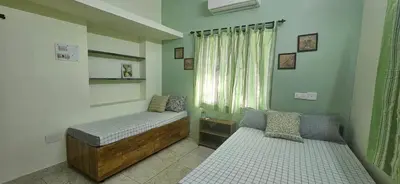 a bedroom with two beds and a window at SHIs Aathira 2bhk Heart of Coimbatore in Coimbatore