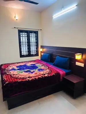 a bedroom with a bed with a colorful blanket on it at G Mount inn in Munnar
