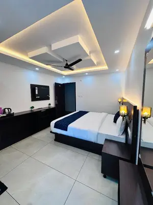 a bedroom with a bed with a ceiling fan at G Mount inn in Munnar