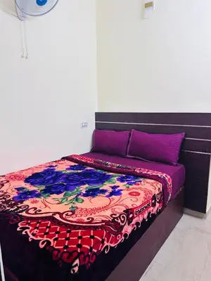 a bed with a colorful blanket on top of it at G Mount inn in Munnar
