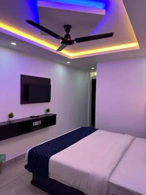 a bedroom with a ceiling fan and a tv at G Mount inn in Munnar