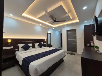 a bedroom with a large bed with a ceiling fan at G Mount inn in Munnar