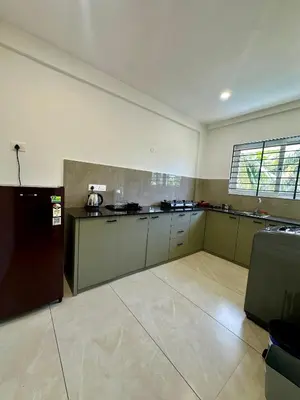 a large kitchen with a refrigerator in a room at Portico Service Apartments in Kozhikode