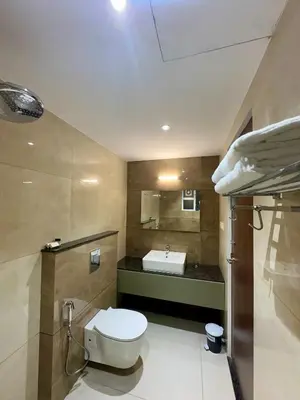 a bathroom with a toilet and a sink at Portico Service Apartments in Kozhikode