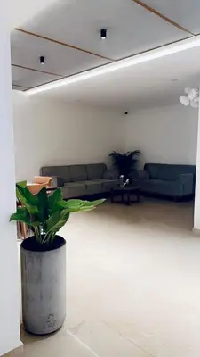 a living room with a couch and a potted plant at Portico Service Apartments in Kozhikode
