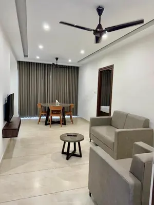 a living room with a couch and a table at Portico Service Apartments in Kozhikode
