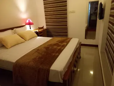 a bedroom with a large bed with a lamp on it at Stains holidayhome & party floor, Cherai beach in Pallipuram