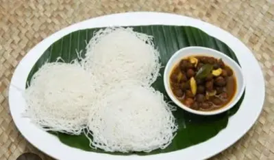 a plate of food with noodles and a bowl of beans at Stains holidayhome & party floor, Cherai beach in Pallipuram