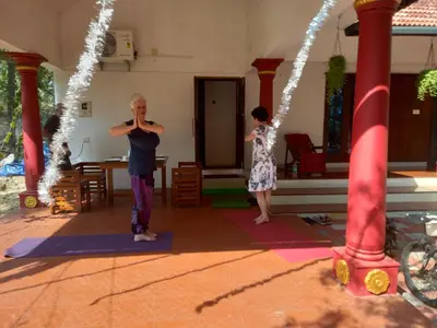 two people doing yoga in a room with lights at Stains holidayhome & party floor, Cherai beach in Pallipuram