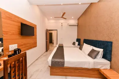 a hotel room with a bed and a flat screen tv at Hotel Shine International in Mysore
