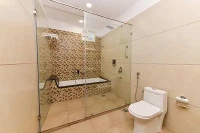 a bathroom with a glass shower and a toilet at Hotel Shine International in Mysore