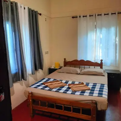 a bedroom with a bed with two towels on it at Perch Next door in Kannur