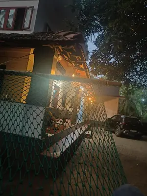 a fence in front of a house at night at Perch Next door in Kannur