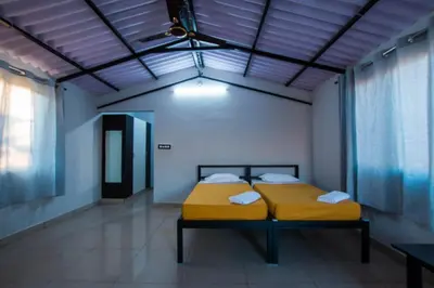 a bedroom with two beds in a room with a ceiling at Valley Vibes in Rāmanagaram