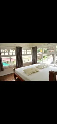 a bedroom with a bed and a large window at Attuvam Valley in Kodaikānāl