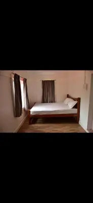 a bed sitting in a room with a window at Attuvam Valley in Kodaikānāl